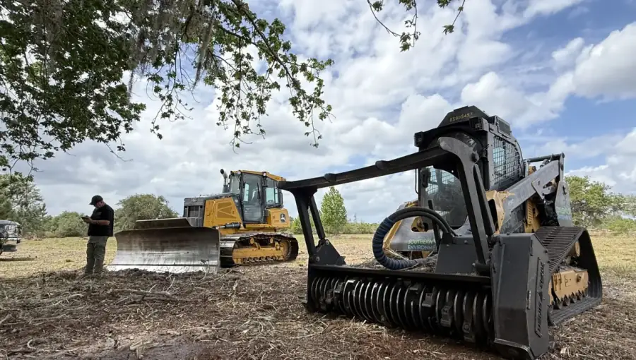 Southern Environmental Group compact track loader with forestry mulcher clearing underbrush in Tampa Bay , forestry mulcher attachment shredding overgrown brush and vegetation for site preparation