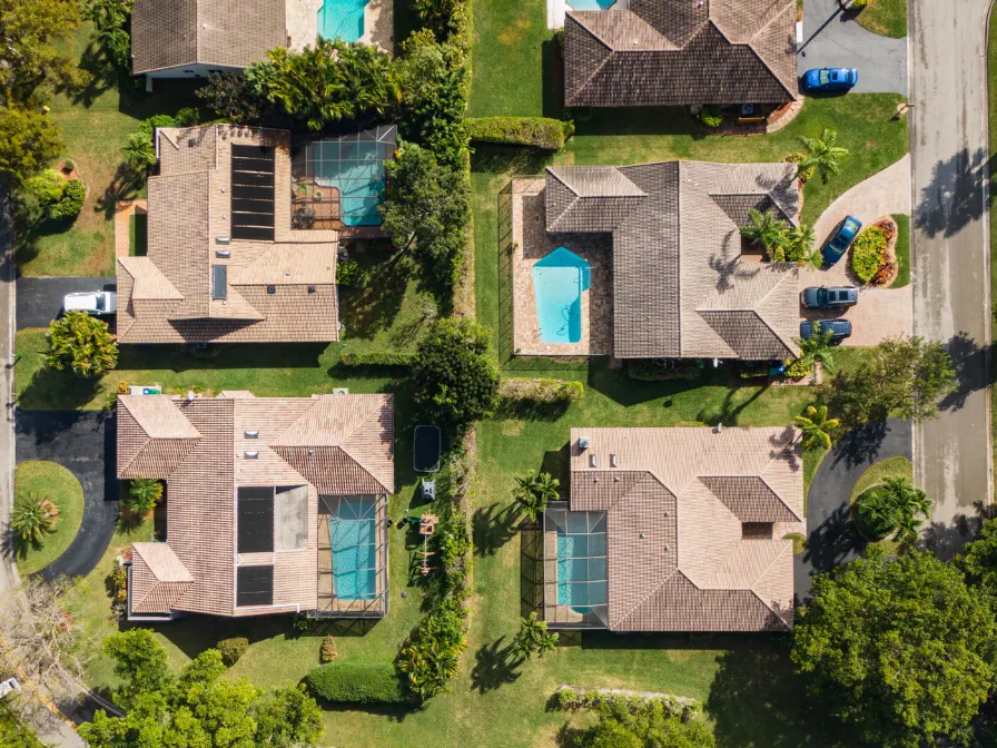 Aerial view of a Central Florida residential neighborhood requiring post-summer landscape recovery and professional tree maintenance after the storm season.