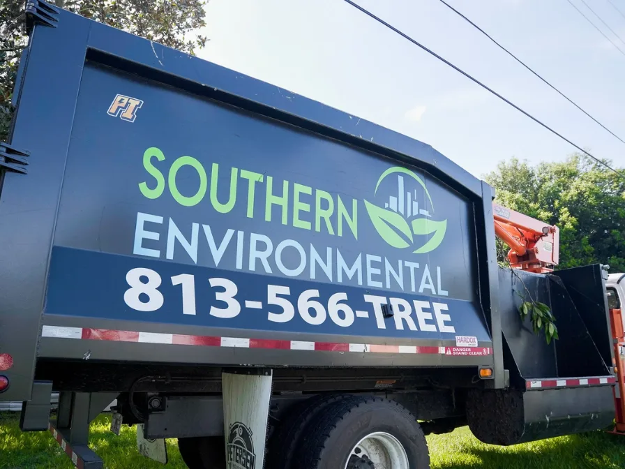 Professional Southern Environmental grapple truck with 813-566-TREE branding, ready for a tree removal project in Central Florida.